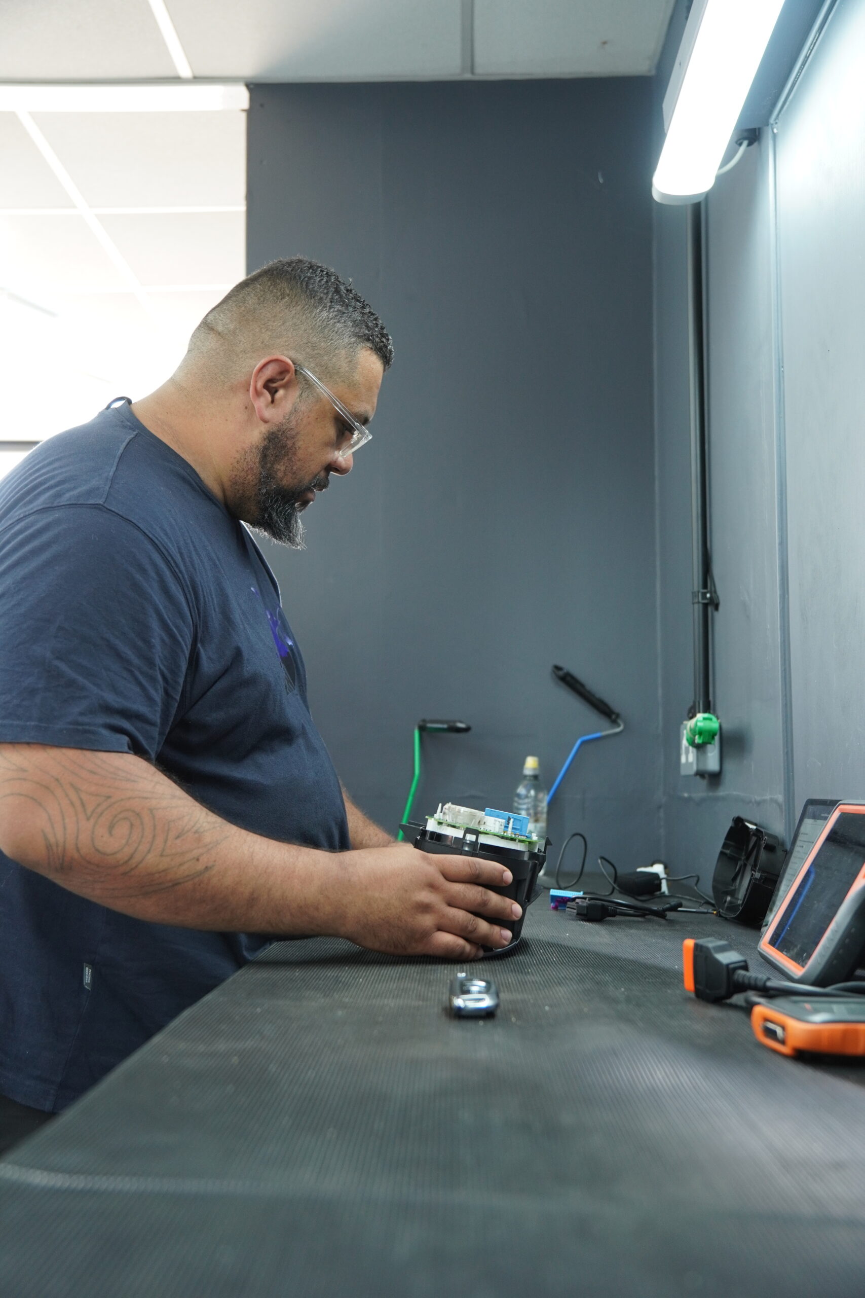 Auto locksmith cutting a replacement car key inside the Unlock & Go mobile workshop